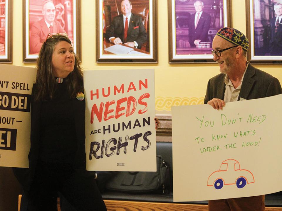 The Rev. Dr. Mandy Todd, left, pastor of Messiah Lutheran Church in Lindsborg, Kan., and Rabbi Moti Rieber, right, executive director of Kansas Interfaith Action, protest a new Kansas law that will invalidate hundreds of driver's licenses and birth certificates for transgender people. AP photo by John Hanna.